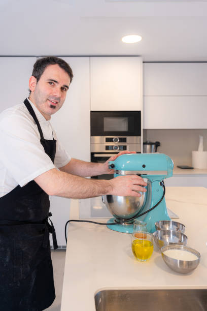 istock A man baker cooking a red velvet cake at home, preparing the cake in the kitchen robot, work at home 1402876751