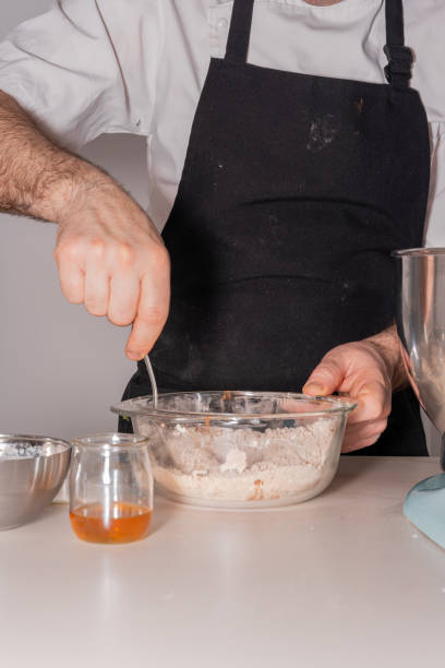 istock A man baker cooking a red velvet cake at home, preparing the cake by adding cocoa powder with flour and yeast in the food processor, work at home 1402876837