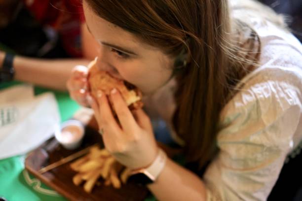 istock Girl eating big burger 1402878577