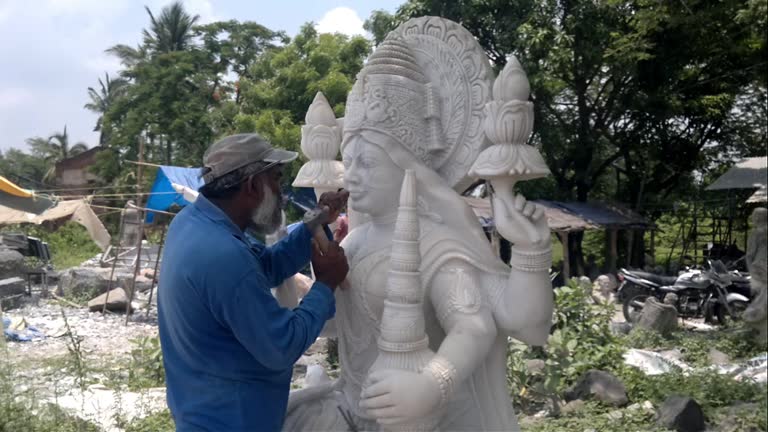 Indian craftsman carving traditional Hindu Goddess Lakshmi or Laxmi White marble stone Sculpture or statue For Sale, Using Hammer And Chisel, hand moving.