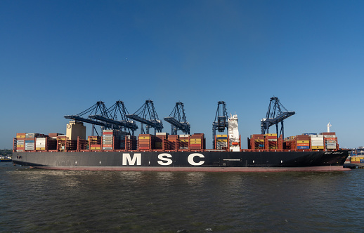 Harwich, United Kingdom - 10 June, 2022: view of a large container ship being loaded in the industrial port of Harwich on the North Sea coast of England
