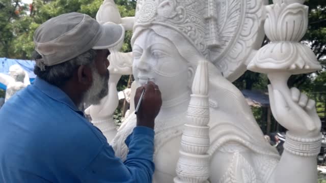 Indian craftsman carving traditional Hindu Goddess Lakshmi or Laxmi White marble stone Sculpture or statue For Sale, Using Hammer And Chisel, hand moving.