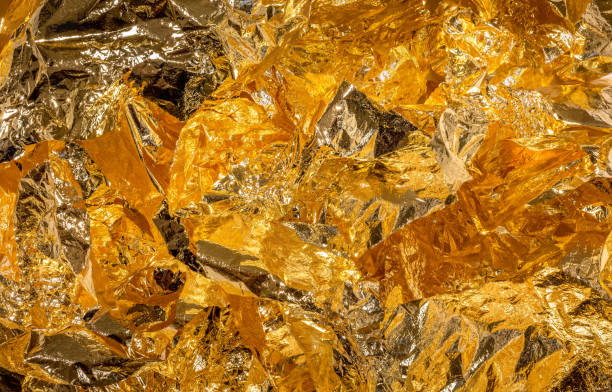 istock Crumbled gold leaves, golden textured background 1402882306