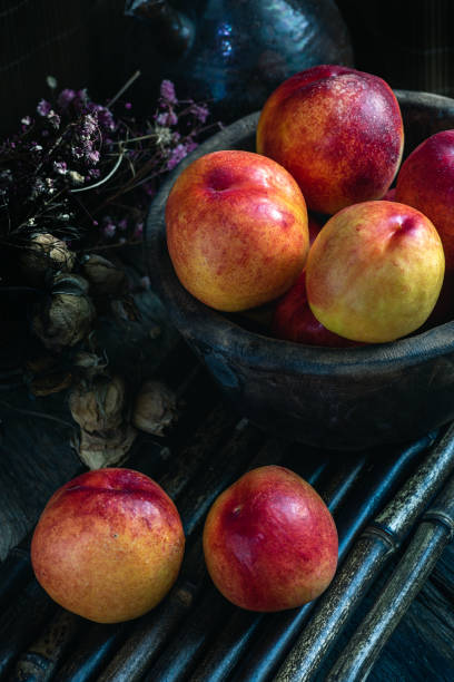 istock Fresh peaches on plates or bamboo tables in dark 1402882444