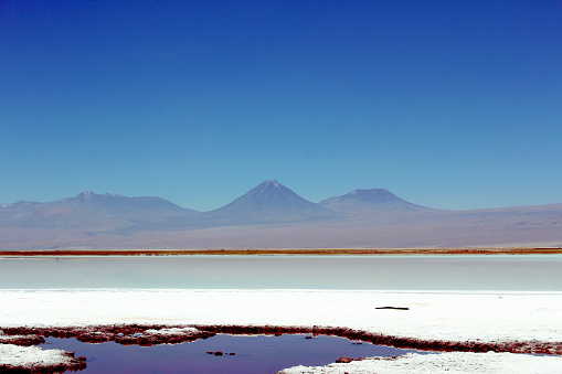 Landscape view of Lake Tebenquiche, volcanoes on background, Atacama desert, Chile.