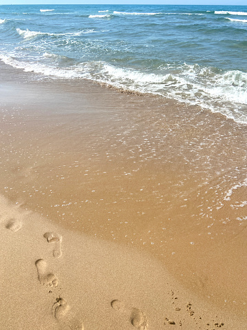 High angle view footprints on the sand at the beach with wave pattern