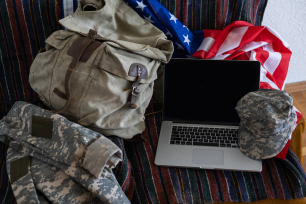 istock backpack and laptop against American flag. Military education 1402883530