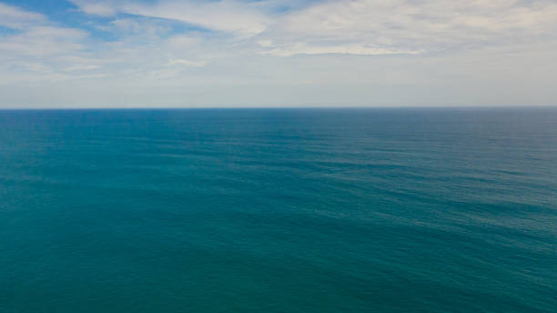 istock Beautiful white clouds on blue sky over calm sea. 1402883542