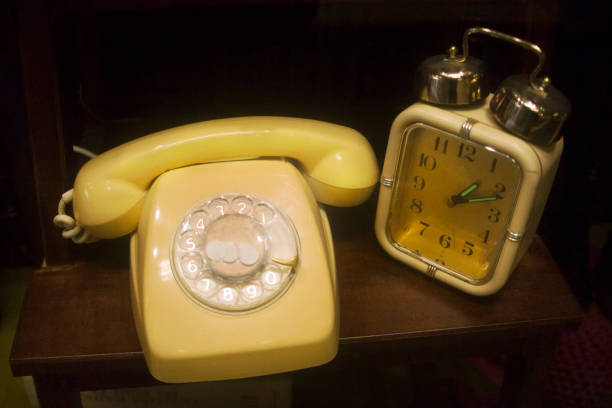 Old-fashioned alarm clock and landline telephone. Antiquities.