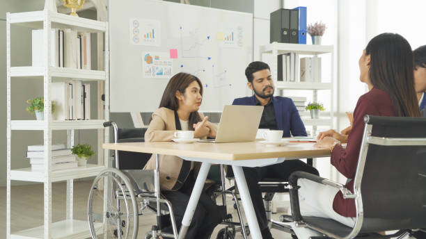 istock Disabled people with a group of Asian business team talk, communicate, discuss, and work in meeting room office, present ideas to colleagues. People lifestyle. Corporation 1402886708