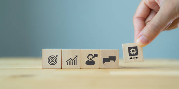 istock AI-CRM solution concept. Data driven marketing strategy with AI. For marketing plan, providing automated interaction to customer. Hand hold wooden cubes with AI-CRM icon on grey background, copy space 1402887611