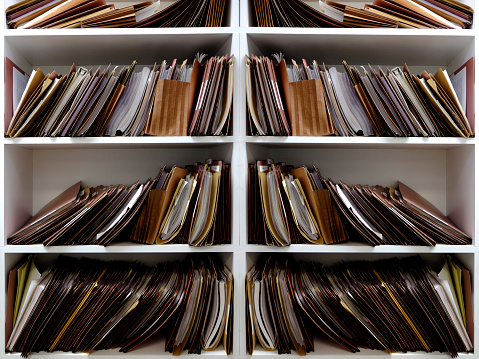 Stacks of Business files in boxes folders on shelf shelves papers