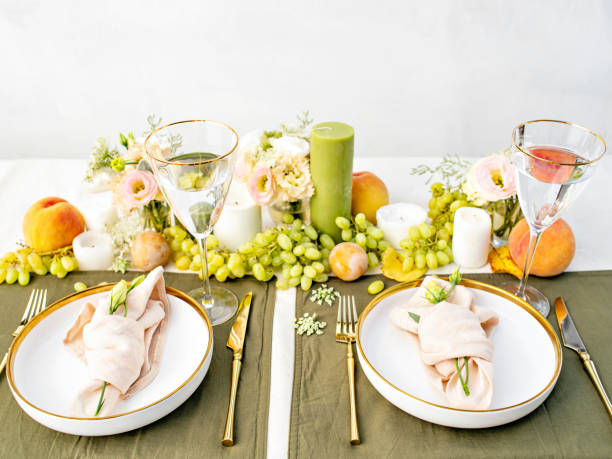 istock Festive table setting for two person. Restaurant, wedding, party decorated with flowers, candles, fruits and leaves. Midsummer or autumn mood event, romantic dinner. Florist decorator occupation. 1402890666