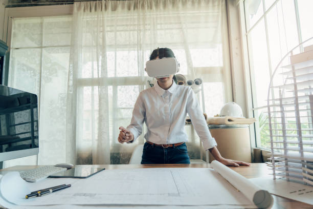 Asian woman Architect worker wearing VR headset for working design architectural with BIM technology. stock photo
