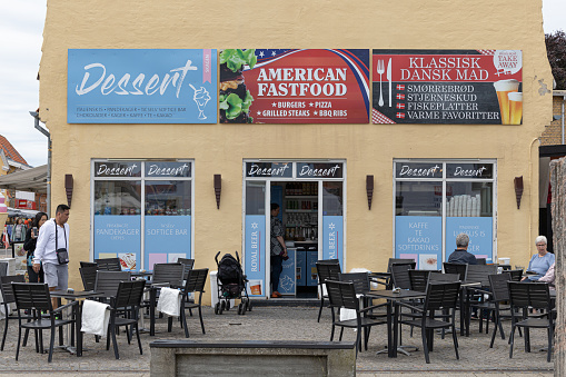 Skagen, Denmark June 7, 2022 The facade of an American fast food restaurant and guests and table.