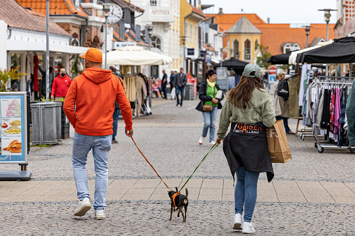 Skagen, Denmark June 7, 2022 A couple walking their dogs on the main shopping street.