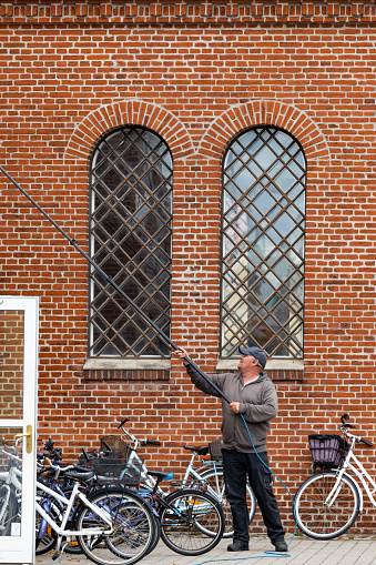 Skagen, Denmark June 7, 2022 A man washes the windows at the Skagen kirke or Skagen Church.