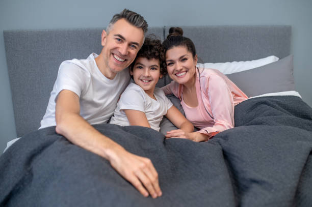 istock A happy family in bed together looking peaceful 1402893225