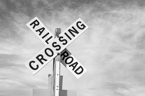 Railroad crossing sign against sky
