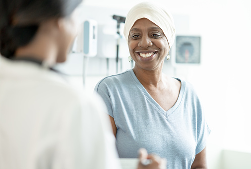 A senior woman wearing a head scarf is seen by her doctor.