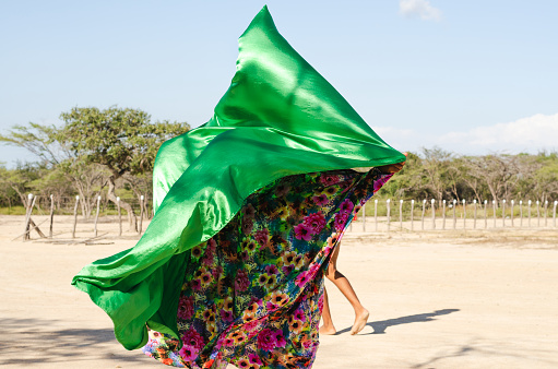 Woman dancing typical Wayuu dance. Indigenous culture of La Guajira, Colombia. Desert landscape.