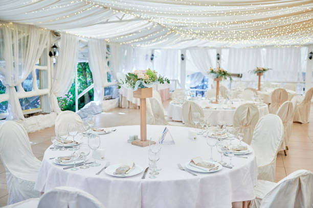 istock Table setting with blank guest card, plates with napkins and cutlery, copy space. Place setting at wedding reception. Round table served for banquet in restaurant 1402895171