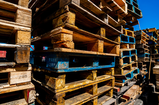 Wooden pallets stacked on a forecourt outside on the street