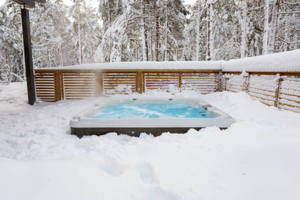 Warm hot tub The warm hot tub invites you to relax in the beautiful winter landscape as the snow slowly falls down. hot tub stock pictures, royalty-free photos & images