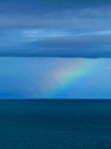 regenbogen über dem ozean - screen saver puzzle painted image light stock-fotos und bilder
