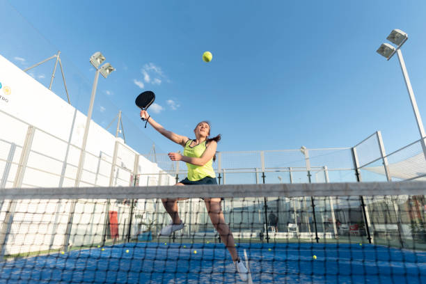 woman playing paddle tennis in court , ready for smash jumping in training sports class - padel stockfoto's en -beelden