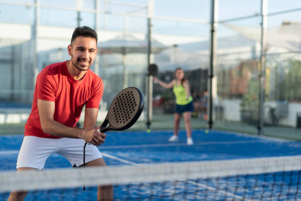 pareja jugando a pádel en corte - tennis couple women men fotografías e imágenes de stock