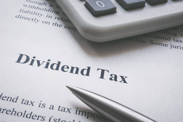 istock Dividend tax information page, calculator and pen. 1402901363