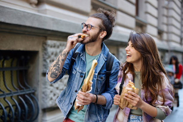 istock Happy couple sightseeing and enjoying their meal while walking 1402901443