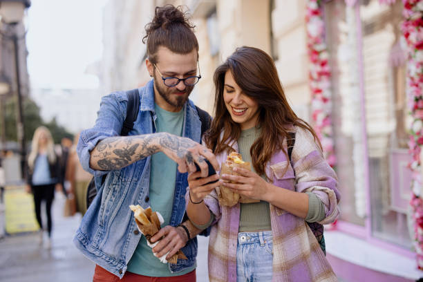 istock Young couple using smartphone while out in the city 1402901449