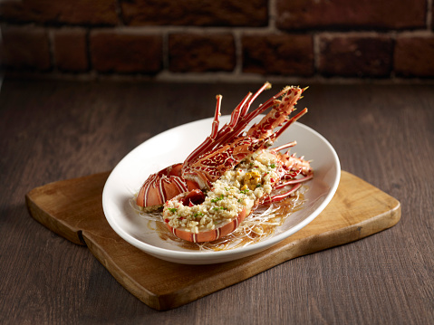 Steamed with Minced Garlic Bamboo Lobster served in a dish side view on wooden background