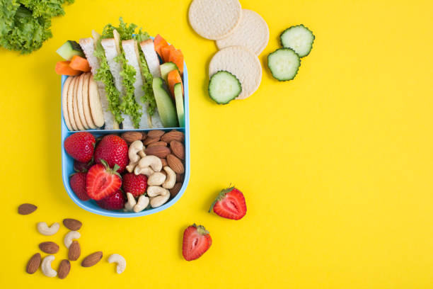 istock School lunch in the blue box on the yellow background. Top view. Copy space. 1402902830