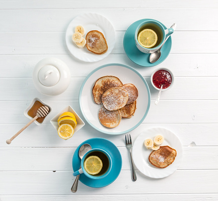 Lovely big organic breakfast with pancakes and delicious tea with pieces of lemon, topview