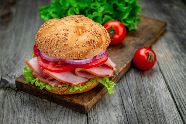 istock Sandwich with ham and vegetables on an old wooden table 1402903348