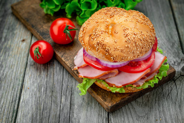 istock Sandwich with ham and vegetables on an old wooden table 1402903377
