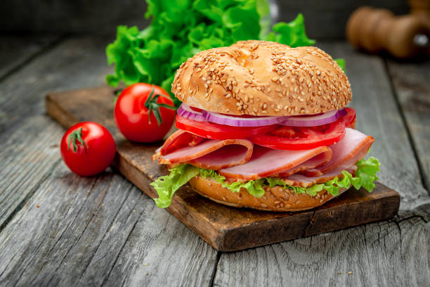 istock Sandwich with ham and vegetables on an old wooden table 1402903414