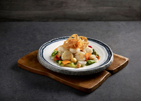 Assorted Vegetables with Scallops served in a dish isolated on mat side view on dark background