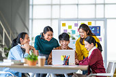 istock Young happy Asian business man, woman work together in start up office. Creative team brainstorm meeting, internet technology, businesspeople colleague partnership, or office coworker teamwork concept 1402906380