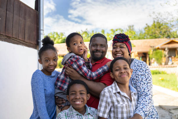 una familia de tres hijos y una hija posan para una foto fuera de su casa - afrocaribeño fotografías e imágenes de stock