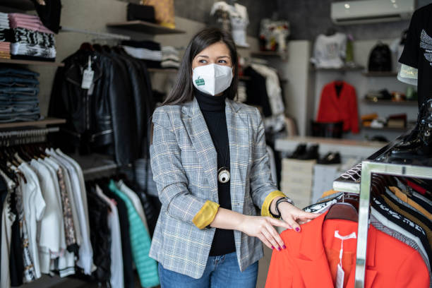istock Smart shop assistant is standing by the clothes on a rail ready for the next customer 1402908301