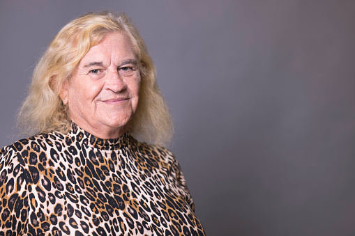 Portrait of an elderly transgender lady wearing a leopard print dress.