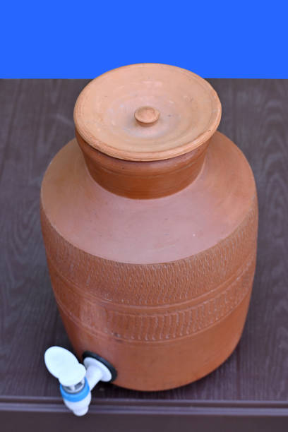 Pithos old culture soil made water jar, pot bottle big mug (pani ka Matka) outside. nature plants grass landscape background