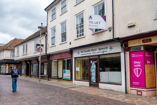 A man walking past a row of empty retail premises in Ipswich, Suffolk, Eastern England. Following COVID-19, the economic climate caused many businesses to fail.