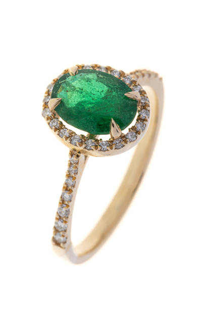 istock Golden engagement ring with diamonds and emerald, isolated on white 1402912749