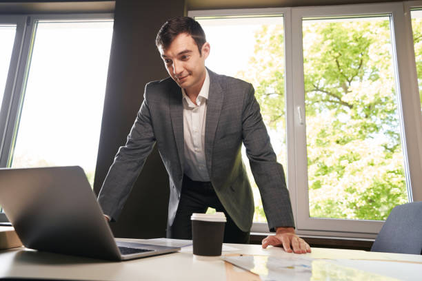 istock Young clerical worker bending over laptop on table 1402914390