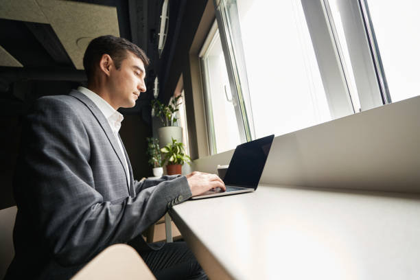 istock Business worker typing on laptop at window desk 1402914424